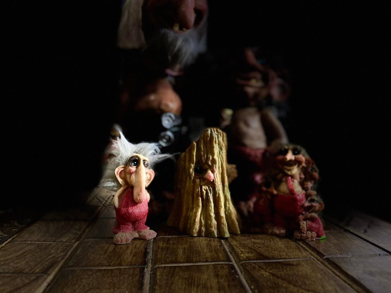 Figuras decorativas de duendes sobre una mesa de madera.